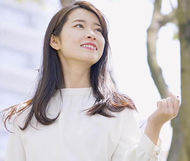 斜め上を向いて微笑んでいる女性