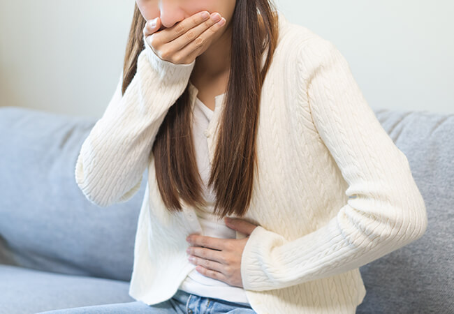 吐き気をもよおす女性